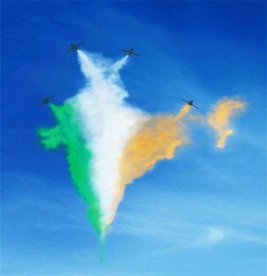 Aircraft drawing the outline of India in green, white and saffron smoke against a blue sky